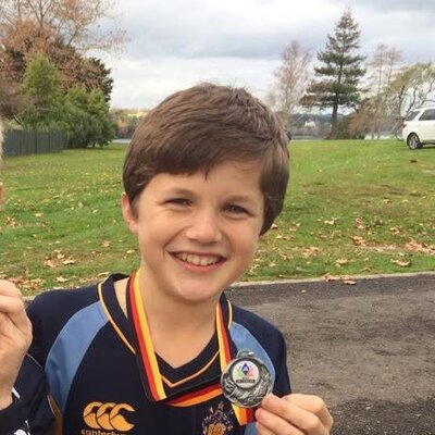 Tristan as a schoolboy proudly holding up a race medal
